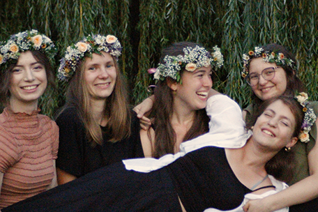 fünf junge Frauen mit Blumenkränzen an einem lauen Spätsommerabend